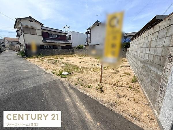 現地土地写真には広々としたスペースがしっかりと映し出されています。周囲には住宅が立ち並び生活のイメージが膨らみやすい環境です。道路に面しており利便性を感じられる一枚です。