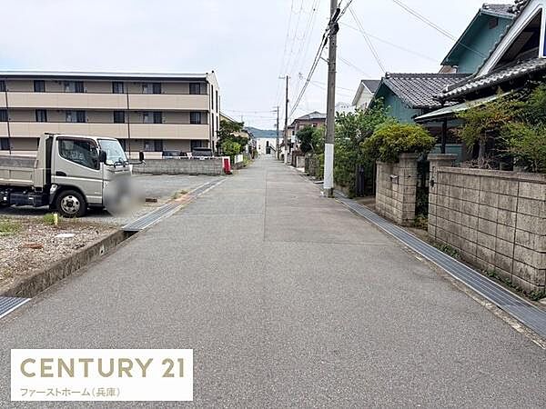 前面道路は幅員があり車の通行もスムーズに行えます。周囲には住宅が立ち並び落ち着いた雰囲気が広がっています。歩道や電線も整備されており見通しの良い道路です。全体的に清潔感が感じられる現地環境です。