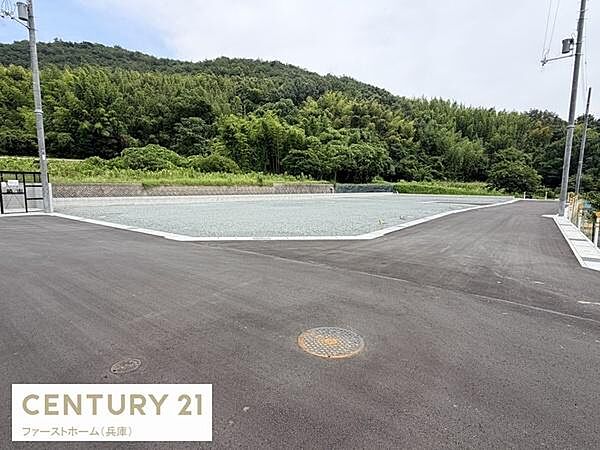 開放感のある現地土地写真です。周囲は緑豊かな環境に囲まれておりゆとりある区画が魅力です。前面道路も整備され車の出入りがしやすい設計です。現地の様子がよく分かる写真となっています。