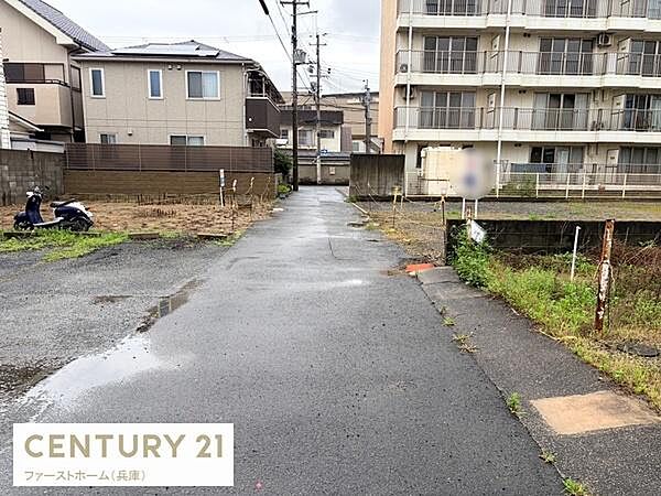 周囲に住宅やマンションがあり落ち着いた現地からの眺望です。道路が広めで開放感があります。前面に視界を遮る高い建物が少ないです。周辺環境がわかる一枚です。