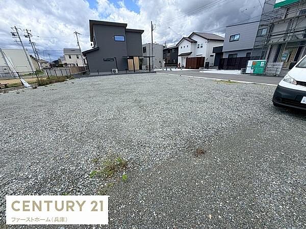 広々とした現地土地写真です。前面道路に面しており交通アクセスに便利な立地です。周囲には住宅が並び安心感のある環境となっています。陽当たりや風通しも良好です。