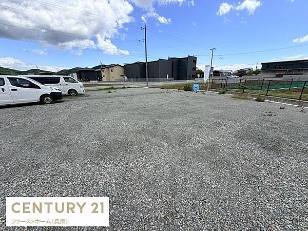 広々とした敷地で様々な用途に適した現地土地写真です。周辺に建物が整然と並び開放感のある環境です。車両の出入りもしやすいスペースが確保されています。整地された状態で活用の幅が広がります。