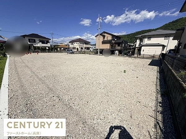 ゆとりのある敷地で活用しやすい現地土地写真です。周囲には住宅が立ち並び落ち着いた街並みが広がっています。見晴らしが良く開放感のある場所となっています。整地された状態なので計画が立てやすい印象です。