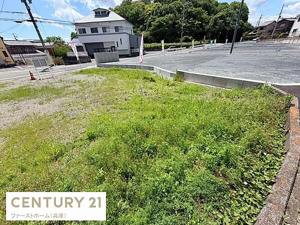 開放感のある角地で日当たりを感じられる現地土地写真です。周囲は舗装されており整備された印象があります。見通しの良い環境で街並みにも調和しています。生活利便性の良さが感じられる立地です。