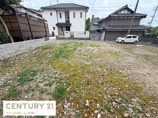 周囲に住宅が建ち並ぶ落ち着いた現地土地写真です。現状更地で使い方の自由度が高い点が魅力です。前面道路に面しており車の出入りもスムーズに行えます。生活利便性の良い立地を感じられる写真です。