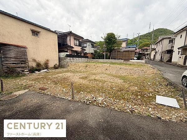落ち着いた住宅街の一画に位置する現地土地写真です。道路に面しているため車の出入りもスムーズです。周囲には住宅が並び安心感があります。整形地となっており多様な用途が考えやすい区画です。