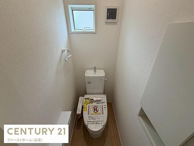 シンプルなデザインで清潔感のあるトイレです。小窓が設置されているため明るく換気も良好です。壁面収納スペースもあり使い勝手の良さが感じられます。照明も配置され明るさが確保されています。