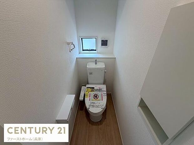 ナチュラルな木目調のフロアが印象的なトイレです。窓付きで明るさと換気が考えられています。壁の収納スペースが便利に使えそうです。白を基調とした清潔感ある空間です。