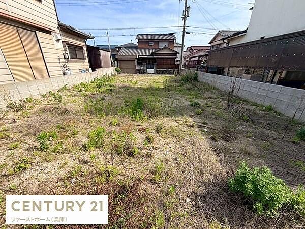 両側に塀が設けられており整形地の現地土地写真です。道路からのアクセスも良好で敷地全体が見通せます。周囲の住宅街と調和した環境が特徴です。日当たりも確保しやすい立地です。
