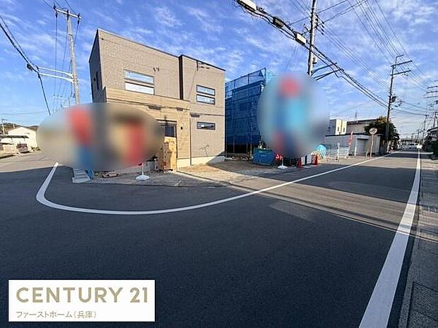 前面道路が広く車の出入りもスムーズに行える環境です。角地に位置し開放感があります。周囲は電柱や電線が整然と配置され視界も良好です。建物の外観はシンプルなデザインで工事中の様子が確認できます。