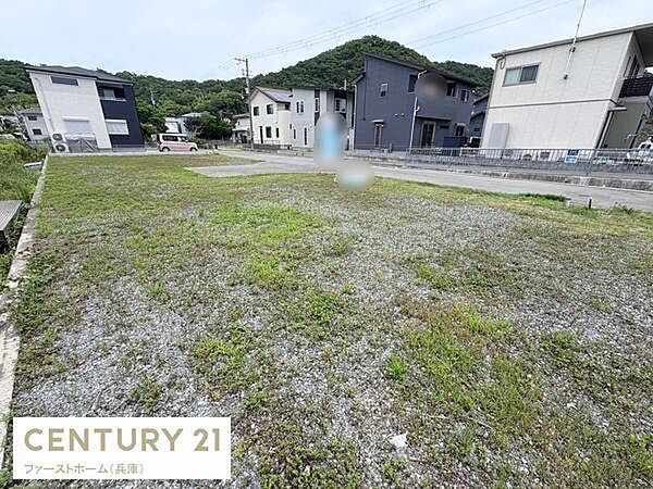 落ち着いた住宅地に位置した現地土地写真です。前面道路が広く車の出し入れがしやすい印象です。周辺には戸建て住宅が立ち並び整った街並みとなっています。敷地内は平坦で活用しやすい地形です。