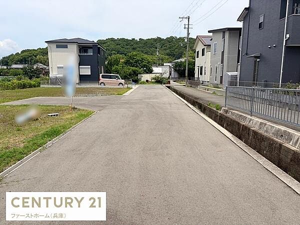 現地からの眺望は開放感のある道路沿いで周囲には住宅が整然と並んでいます。奥には緑豊かな景色が広がり静かな環境が伝わってきます。視界を遮るものが少なく広がりを感じられます。