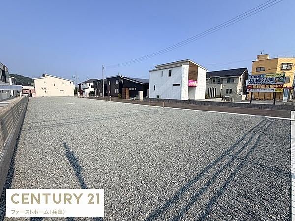 広々とした現地土地写真です。周囲には住宅や店舗が並び見晴らしの良さが感じられます。整地済みの状態で敷地の使いやすさが伝わります。道路に面しておりアクセスもスムーズです。