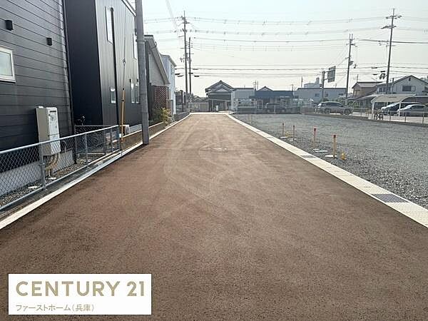 前面道路がしっかり整備され車両の出入りがしやすい環境です。周辺には住宅が広がり落ち着いた雰囲気が感じられます。道路沿いのスペースも広く使い勝手が良い現地写真です。