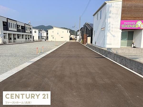 前面道路が広く車の出入りがしやすい現地写真です。新しい街並みが整っています。歩道も整備されていて建物との距離も確保されています。周辺には複数の住宅が立ち並び環境が整っています。