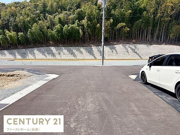 目の前の道路は舗装が施され車の出入りがしやすい設計です。ゆとりある道幅が確保されており安心してご利用いただけます。周囲には自然も広がり落ち着いた雰囲気が感じられる道路です。