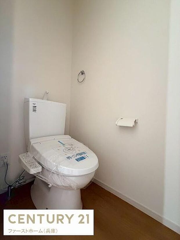 シンプルで清潔感のあるトイレ空間です。コンセント付きで便利な設備も備わっています。ペーパーホルダーやタオルリングも設置されており使い勝手が良いレイアウトです。ゆとりあるスペースが確保されています。