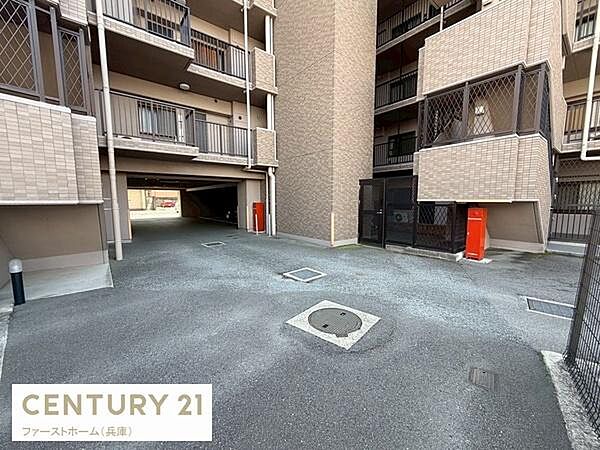 マンションの共用スペースがしっかりと整備されています。駐輪場や駐車スペースも確保されています。建物の外観は落ち着いたデザインです。防犯対策として門扉も設置されています。