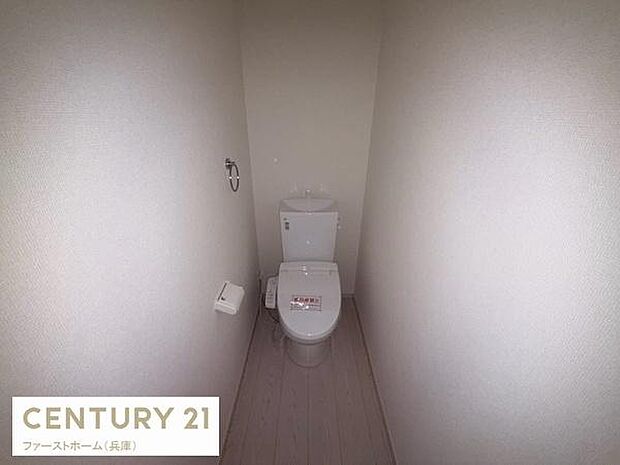 トイレはシンプルな内装で清潔感があります。壁も明るい色合いで圧迫感を感じにくいデザインです。トイレットペーパーホルダーも設置されており利便性も考えられています。