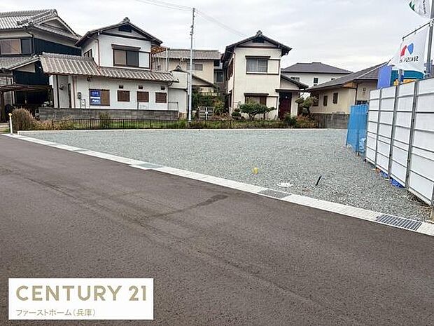 現地写真には周囲に住宅が並ぶ落ち着いたエリアが映っています。前面道路は舗装され車両の出入りがしやすい環境です。敷地は整地されており建築計画が立てやすい土地です。