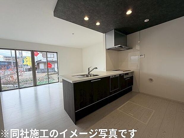 開放的な窓から明るい光が差し込むキッチンです。対面式のレイアウトで空間が広く感じられます。落ち着いた色合いの天井と床がスタイリッシュな印象を与えます。