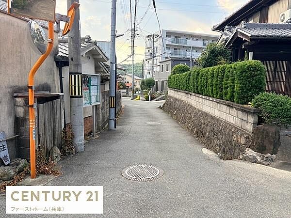 前面道路は静かな住宅街に位置し周辺の住宅や緑も整っています。電柱やミラーも設置されており安全面にも配慮されています。周辺の雰囲気が感じられる現地写真です。見通しの良い道幅で歩行もしやすい印象です。