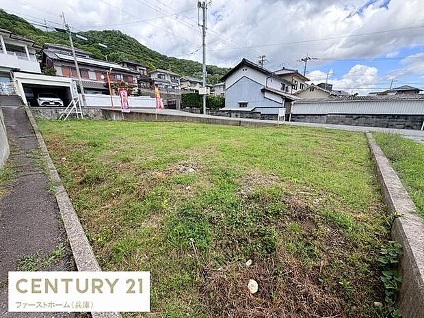 開放感のある現地土地写真です。周辺には住宅が立ち並び敷地がしっかりと確保されています。前面道路との高低差が少なく整形地のため活用がしやすい印象です。現地の雰囲気や周囲の環境も確認できます。