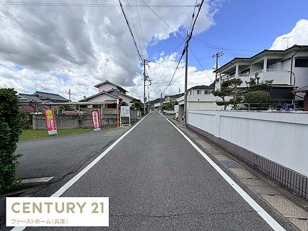 前面道路は幅員が広く車のすれ違いもしやすい環境です。周辺は整然とした住宅街で落ち着いた雰囲気が感じられます。視界が開けており明るい印象の現地写真です。舗装された道路が続き日々のアクセスも安心です。