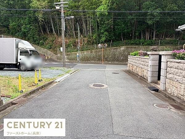 前面道路は広々としており車の出入りがしやすい印象です。周囲に自然が多く落ち着いた環境が広がっています。道路沿いには高い擁壁がありしっかりとした造りが見受けられます。