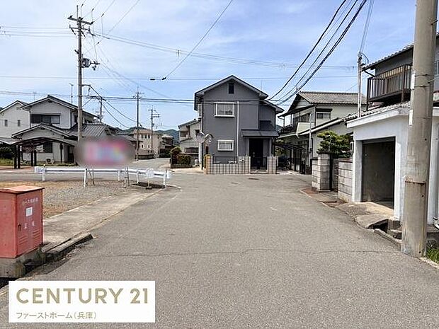 前面道路は広さがあり車の出し入れがしやすい環境です。周囲には戸建てが立ち並び落ち着いた雰囲気が感じられます。道路沿いには電柱やフェンスがあり街並みが整っています。