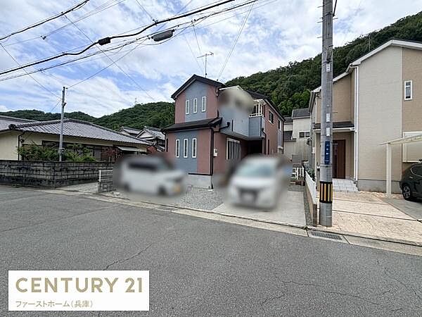 バルコニーが2階部分に設けられており外観にアクセントを加えています。周囲は自然に囲まれた静かな雰囲気が特徴です。住宅街に位置しゆったりとした駐車スペースも魅力的です。