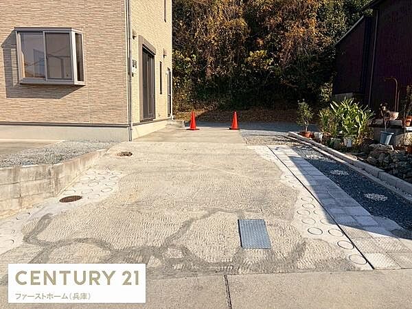 建物横に広めの駐車スペースが確保されています。舗装されたエリアでお車の出し入れもスムーズに行えます。周囲に植栽や鉢植えがあり外観もすっきりとしています。建物へのアクセスが便利な配置です。