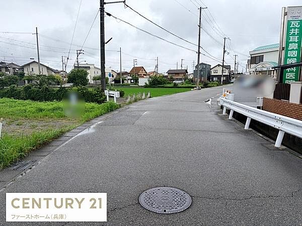 前面道路は幅があり車のすれ違いも安心して行えます。周囲は住宅が並び落ち着いた雰囲気です。きれいに舗装された道路が印象的です。街路樹や緑も身近に感じられます。周辺施設も確認しやすい立地です。