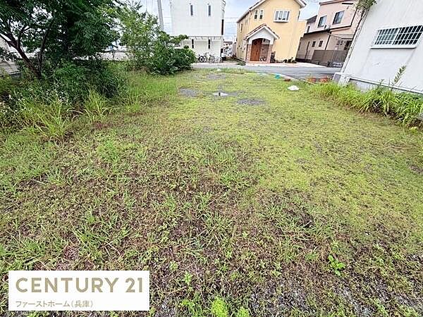 現地土地写真から敷地の全体像がよくわかります。周囲には住宅が立ち並び落ち着いたエリアの一画となっています。敷地は整形で建築計画も立てやすい形状です。