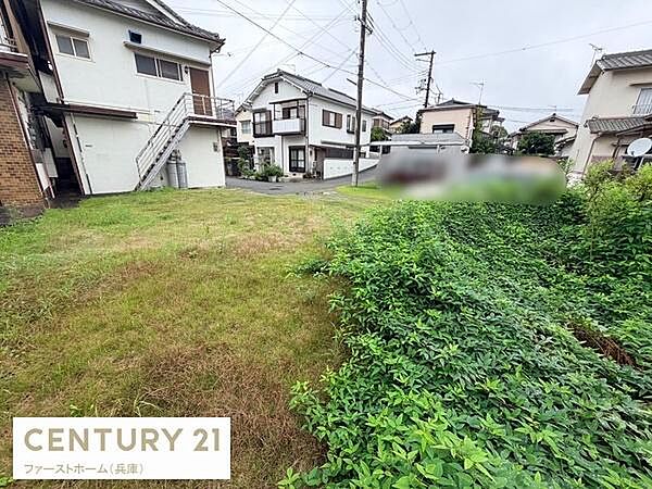 周辺には住宅が建ち並び閑静な環境が感じられる現地土地写真です。道路からのアクセスがしやすく建築の自由度を感じさせます。草木が広がるスペースもあり使い方に幅が出せます。