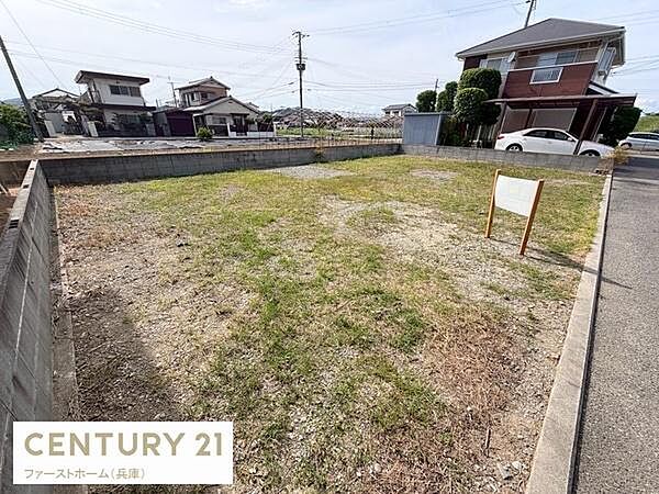 開放感のある現地土地写真です。道路に面した敷地で周囲との距離感も確保できます。整形地となっており用途に合わせて柔軟な活用が可能です。周辺に住宅が多く落ち着いた雰囲気です。