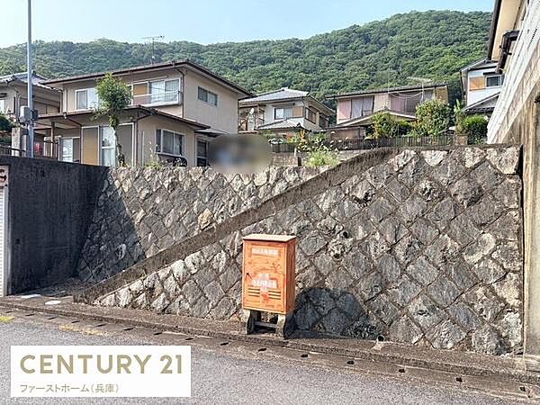 緑豊かな環境が広がる現地土地写真です。周囲は閑静な住宅街で落ち着いた雰囲気が魅力的です。現地の様子をしっかりご確認いただけます。石積みの擁壁が敷地をしっかりと支えています。