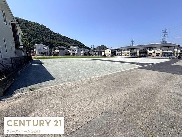 開放感のある現地土地写真です。周囲には住宅や緑が広がり明るい陽射しが差し込む印象です。前面道路も広々としており落ち着いた雰囲気があります。建築の計画が立てやすい土地形状です。