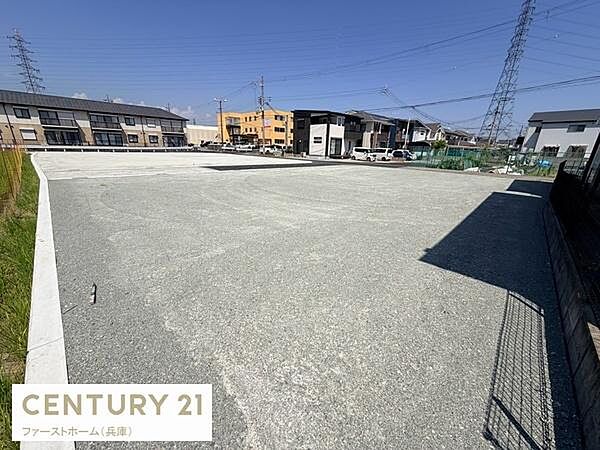 広々とした現地土地写真です。平坦に整地されており道路へのアクセスもしやすい環境です。周辺には住宅や建物が整然と並んでいます。陽当たりも期待できる立地です。