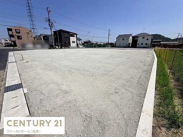 広々とした現地土地写真です。周囲に住宅があり道路へのアクセスも良好です。フラットな形状で計画が立てやすい土地となっています。建築の自由度が高い点も魅力です。
