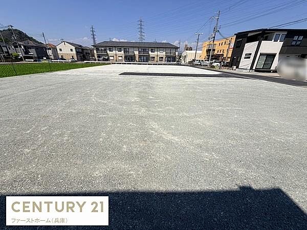 現地土地写真は広々とした敷地が印象的です。周囲には住宅や建物が整然と並んでおり街並みも整っています。道路やインフラも整備されている様子が確認できます。開放感のある空間が広がっています。