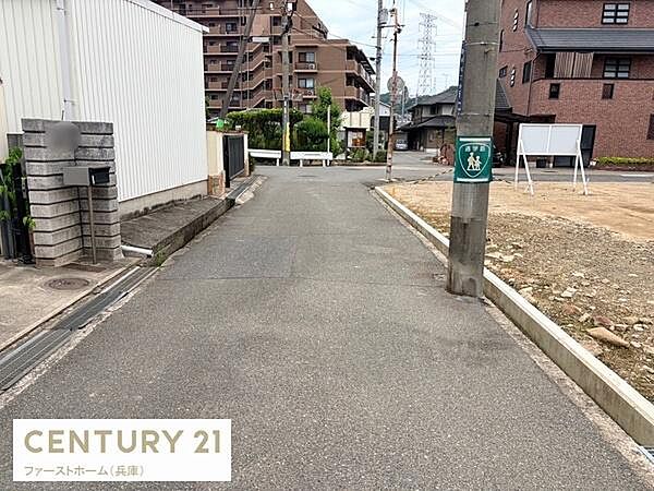 前面道路を含む現地写真です。道路幅員が確保されており車や歩行者の通行もスムーズに行えます。周辺には住宅やマンションが見え落ち着いた住環境です。現地の様子が分かりやすく確認できます。