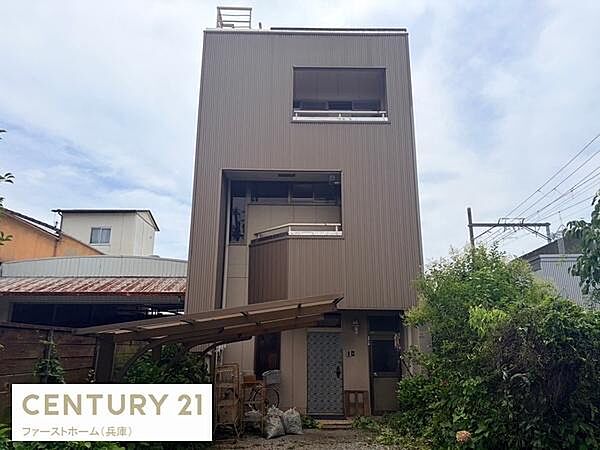 スタイリッシュな外観が目を引く建物です。バルコニー部分は高い位置に設けられていて周囲の建物と距離感があります。外壁や窓の配置がシンプルで印象的です。敷地内には緑があり落ち着いた雰囲気が感じられます。