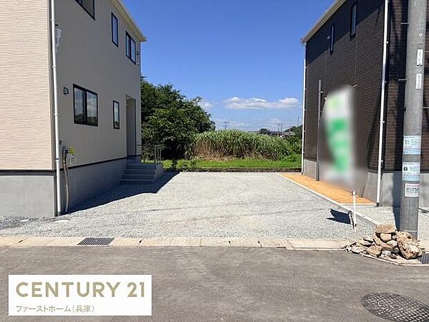 駐車場は平坦な砂利敷きで車の出入りがしやすい設計です。隣接する住宅とは十分なスペースが確保されています。前面道路との段差も少なく使いやすい状態です。周囲が開けているため視界も良好です。