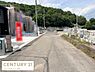 その他：前面道路がしっかりと舗装されており周囲には自然豊かな緑が広がっています。建設中の建物や資材も整然と配置されており進行中の開発エリアであることが感じられます。