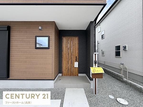 シンプルで洗練された玄関が外観の印象を引き立てます。木目調のドアが温かみを感じさせ落ち着いた雰囲気を演出しています。軒下のスペースが雨天時の出入りに便利です。