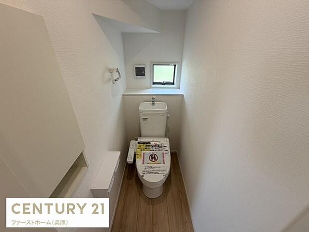 小窓が設置されており換気に配慮されたトイレです。シンプルな内装で清潔感があります。床材のデザインもアクセントになっています。手洗いスペースも備えています。収納スペースも確保されています。