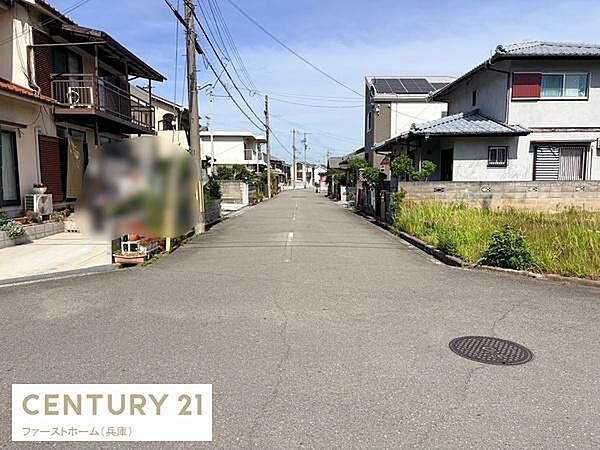 現地写真から周辺環境の様子が確認できます。前面道路は幅員が十分で車の通行がしやすい印象です。住宅が立ち並ぶ静かなエリアです。敷地まわりに緑も見られ開放感があります。