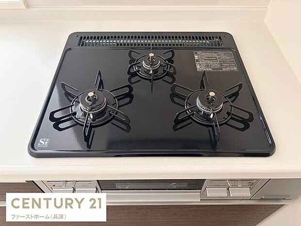 三口コンロが備わったキッチンです。見た目もすっきりとしたデザインでお手入れも簡単な作りとなっています。使いやすさに配慮された配置で調理がしやすい印象です。フラットな天板が特徴です。