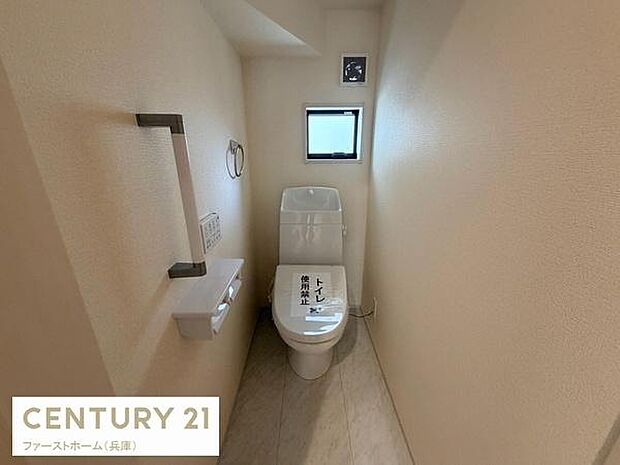 明るい色合いの壁が落ち着いた印象を与えます。小窓が備わっており換気しやすい空間です。手すりやペーパーホルダーが設置されていて便利です。シンプルなデザインで使いやすいトイレです。